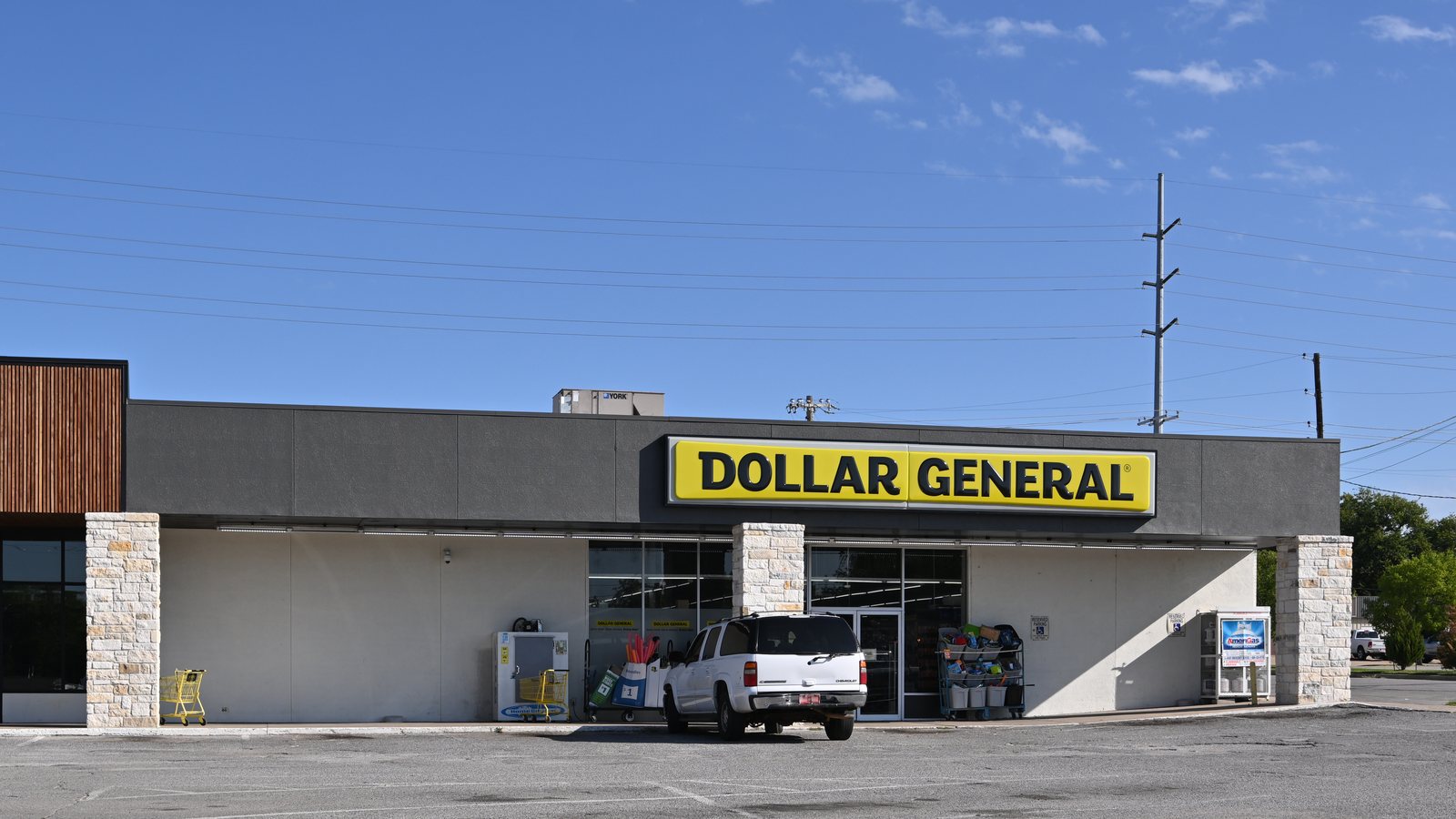 A Dollar General store with its yellow and black sign, a white SUV parked out front, in Sapulpa, Oklahoma