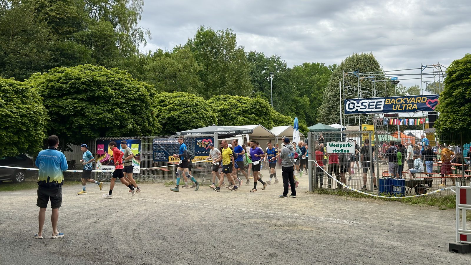 Runners set off on a new hourly loop under an O-SEE Backyard Ultra banner in Zittau, Germany